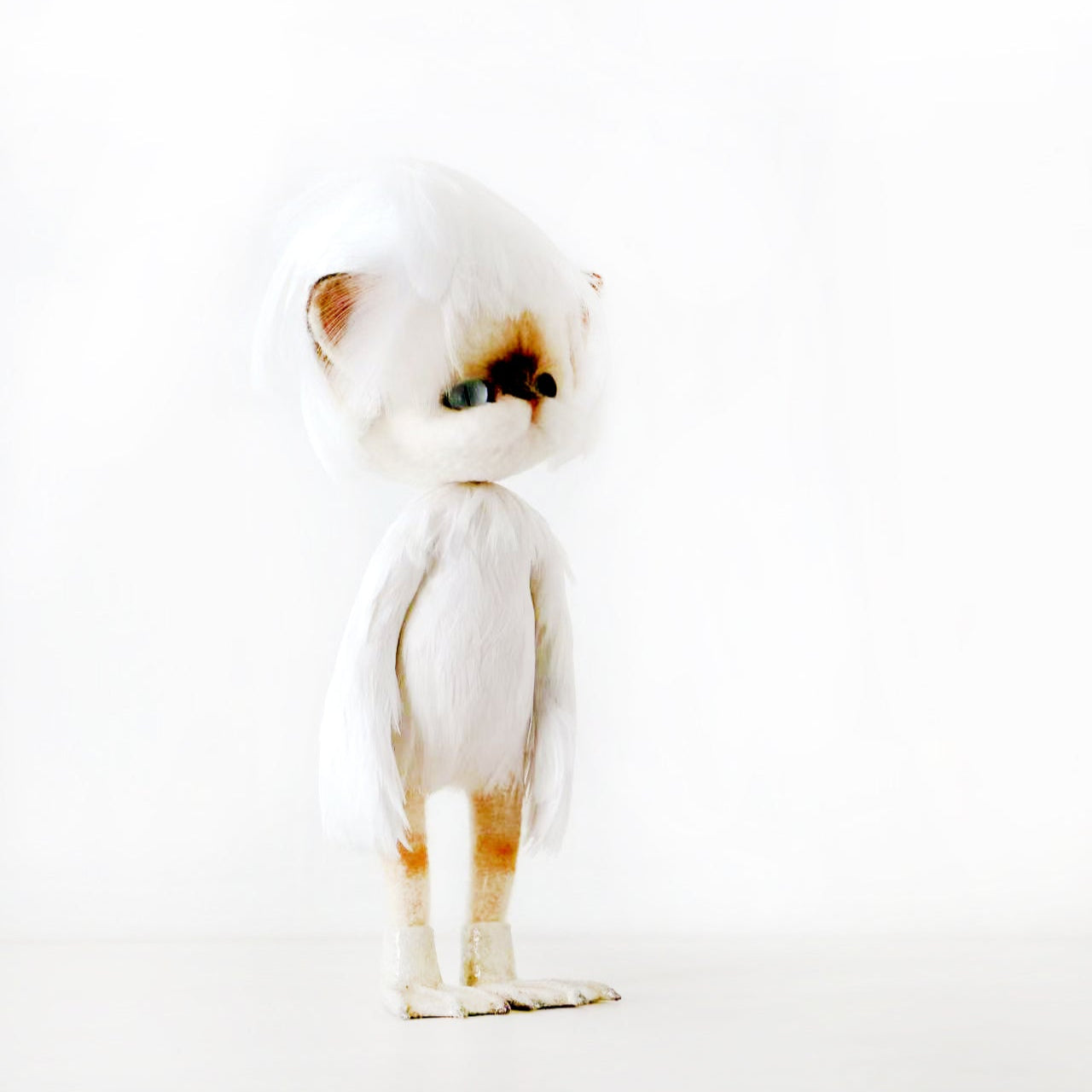 Chat tricoté en feutre de laine en tenue blanche