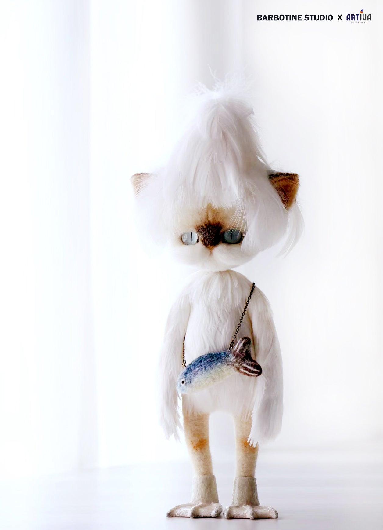 Chat tricoté en feutre de laine en tenue blanche